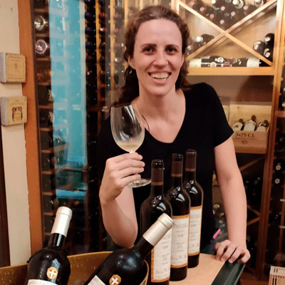 Foto da colunista Giuliana Nogueira segurando uma taça de vinhos na mão 