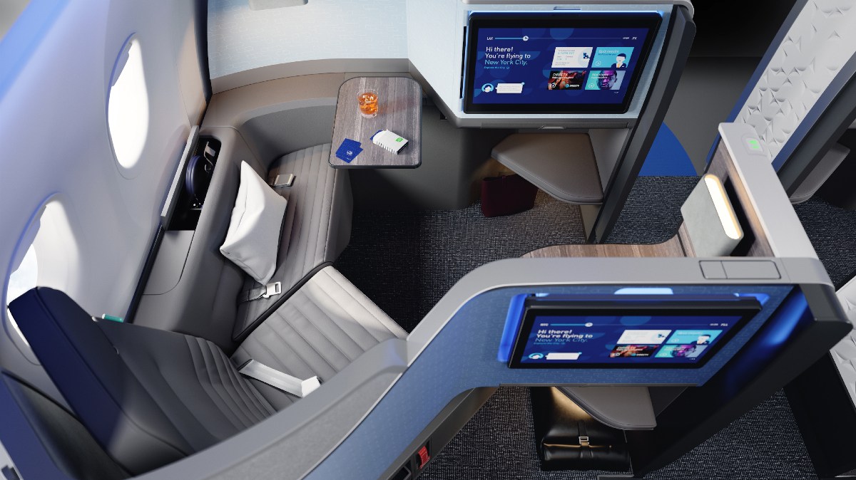 Suíte privativa Mint da companhia aérea JetBlue, com portas com um sofá