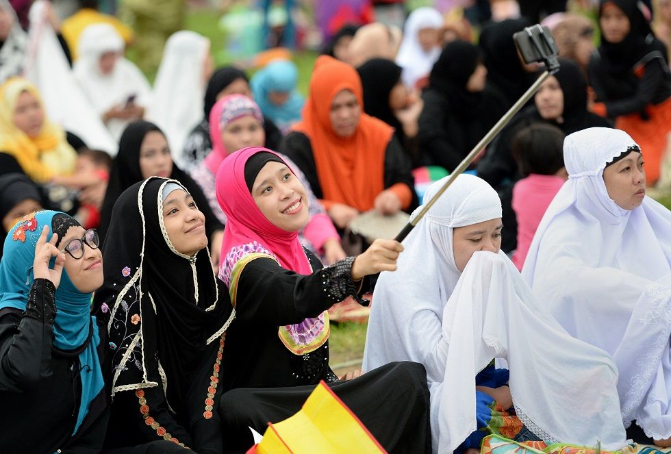 Jovens muçulmanas tiram uma "selfie" antes das orações de sexta-feira para marcar o fim do Ramadão em Manila, Filipinas, em 2021