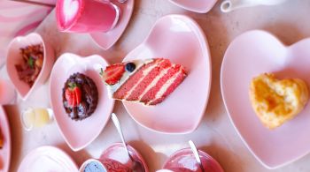 Espaço Instagramável conta com pratos cor de rosa em um ambiente com corações e pontos coloridos para fotos no mood da boneca