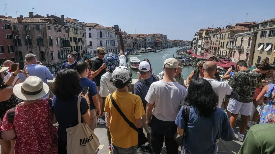 Turistas se aglomeram na Ponte de Rialto em Veneza em agosto.