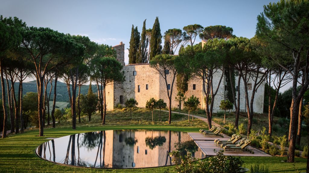 Piscina, jardins e castelo do hotel do Castello di Reschio, na Itália