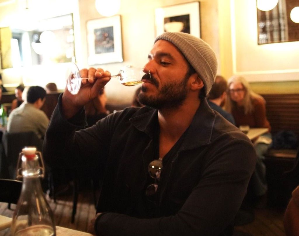 Chef Thiago Castanho toma vinho em um restaurante em Nova York