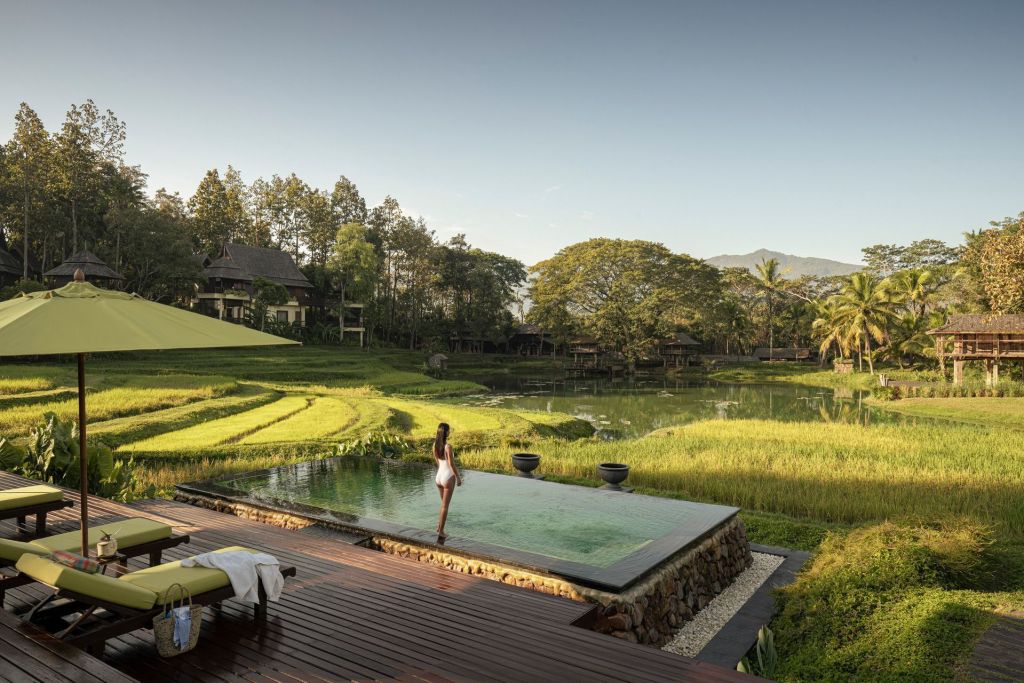 Piscina do Four Seasons Chiang Mai em meio a campos de arroz na Tailândia