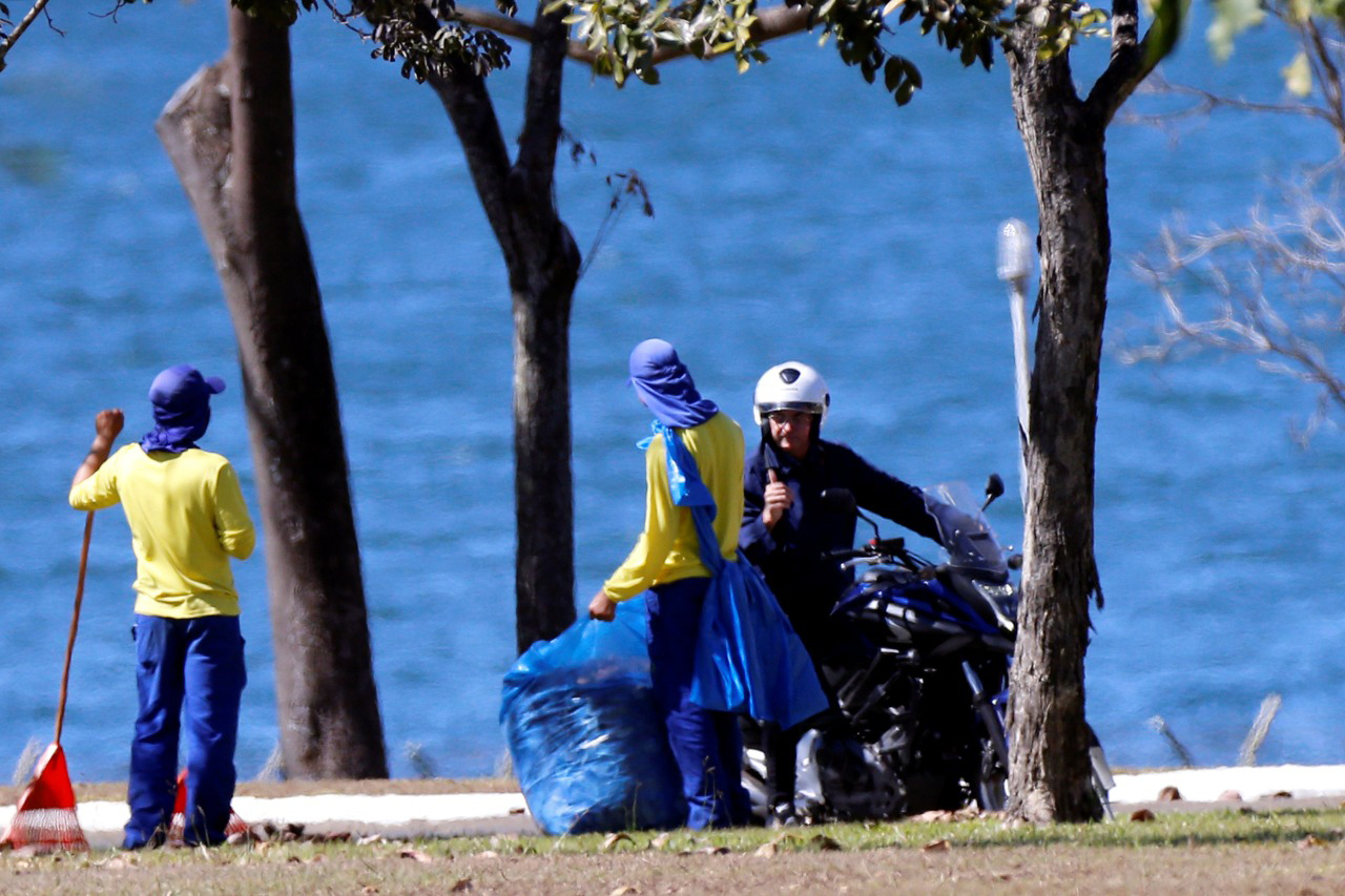 Presidente Jair Bolsonaro passeia de moto e cumprimenta funcionários