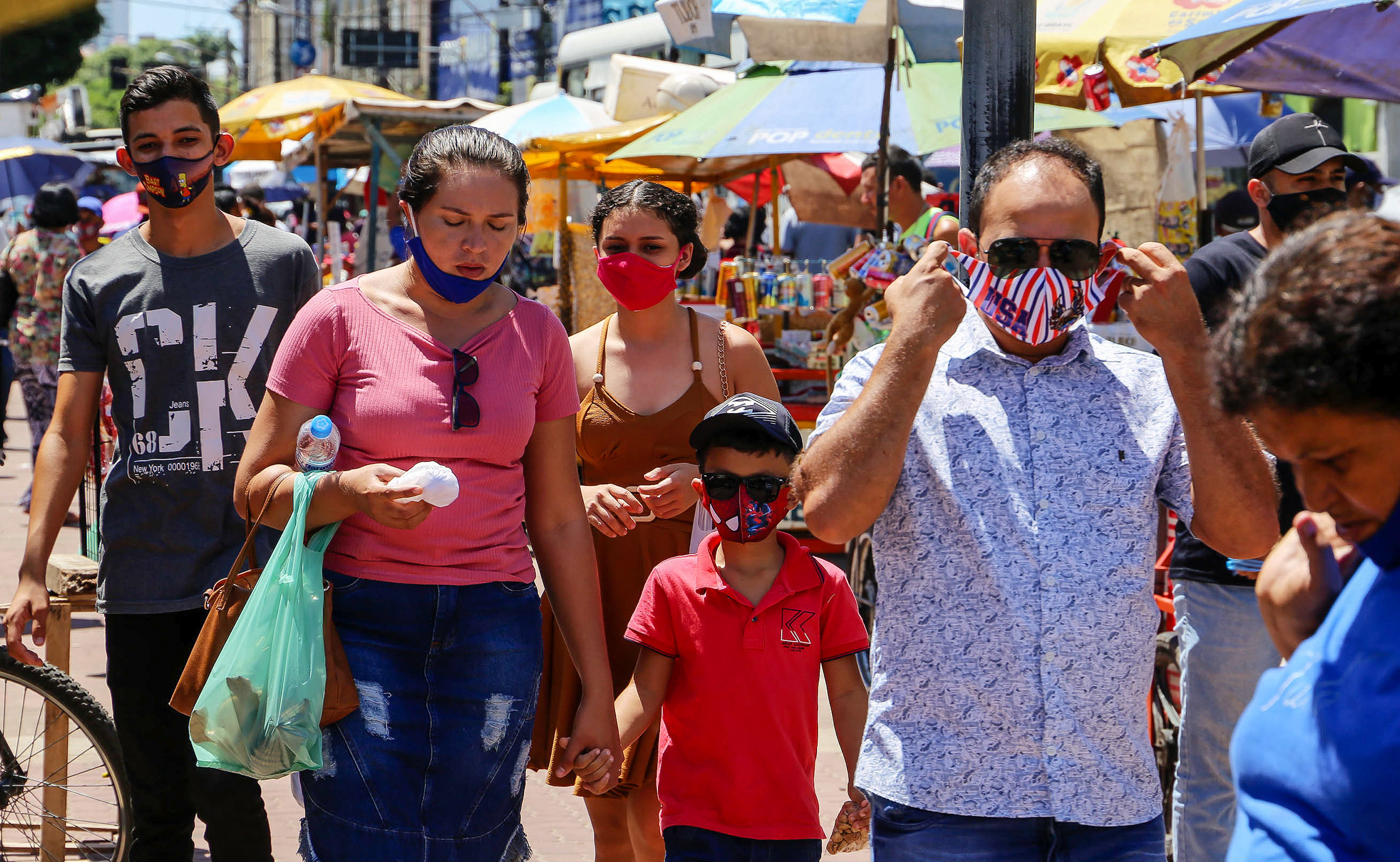 Pessoas de máscara caminham em Belém, no Pará