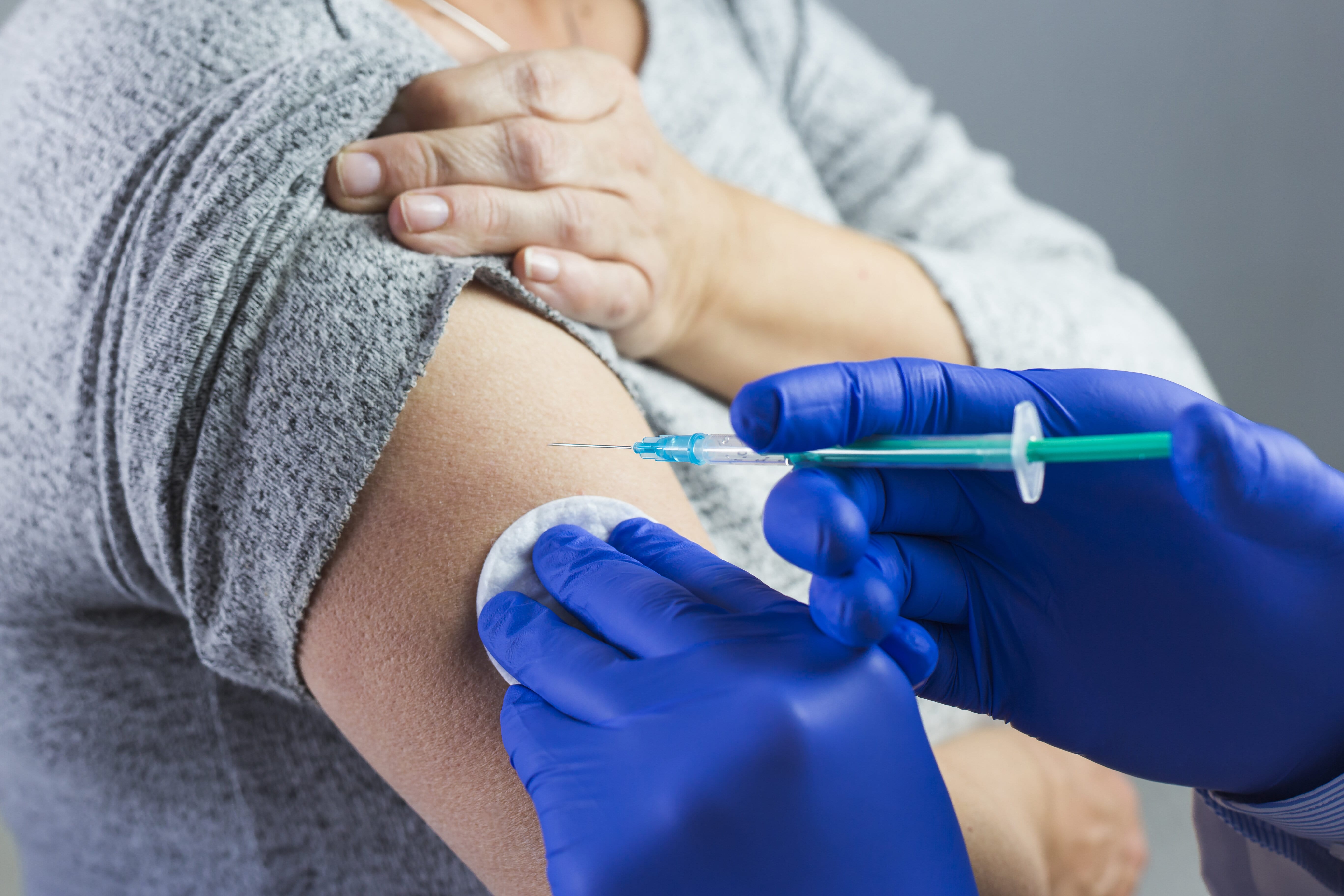 Enfermeira aplicando vacina em braço