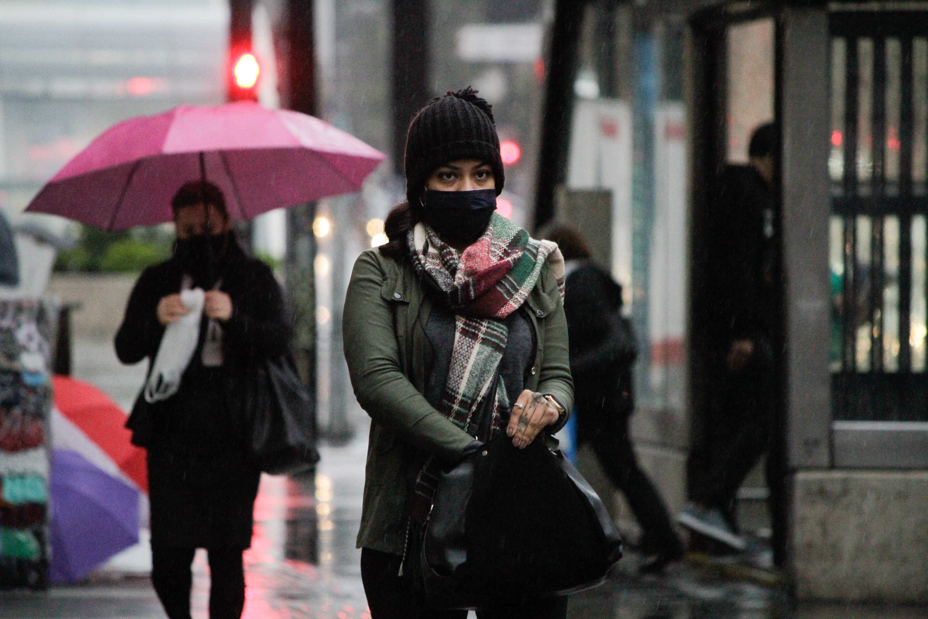 Pedestres se protegem do frio e da chuva na Avenida Paulista, em SP
