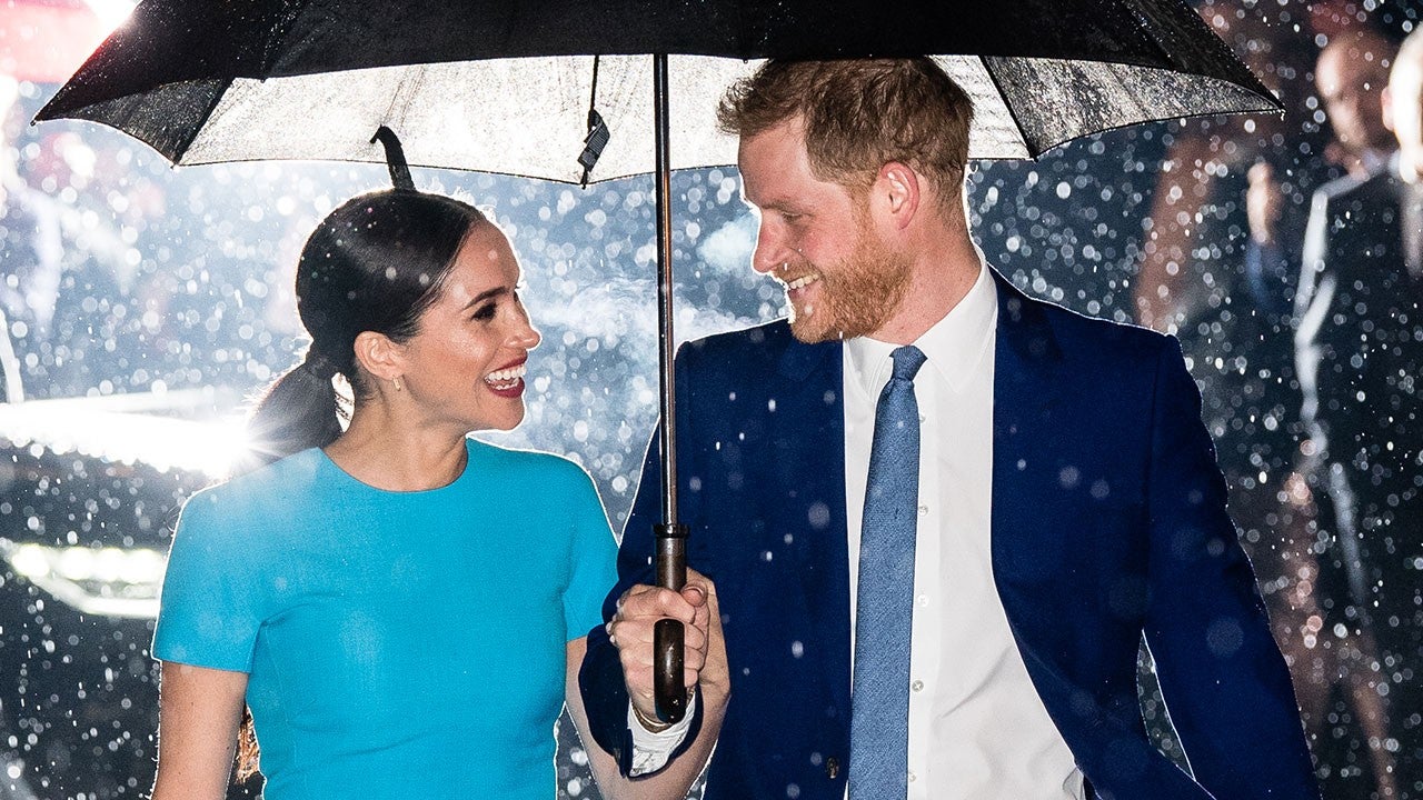 Harry e Meghan fotografados em baixo de guarda chuva