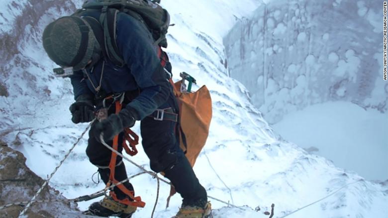 Alpinista descendo a cratera na tundra siberiana