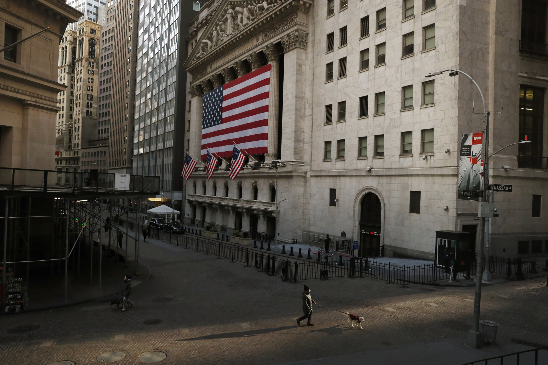 Homem caminha pela Wall Street, em Nova York