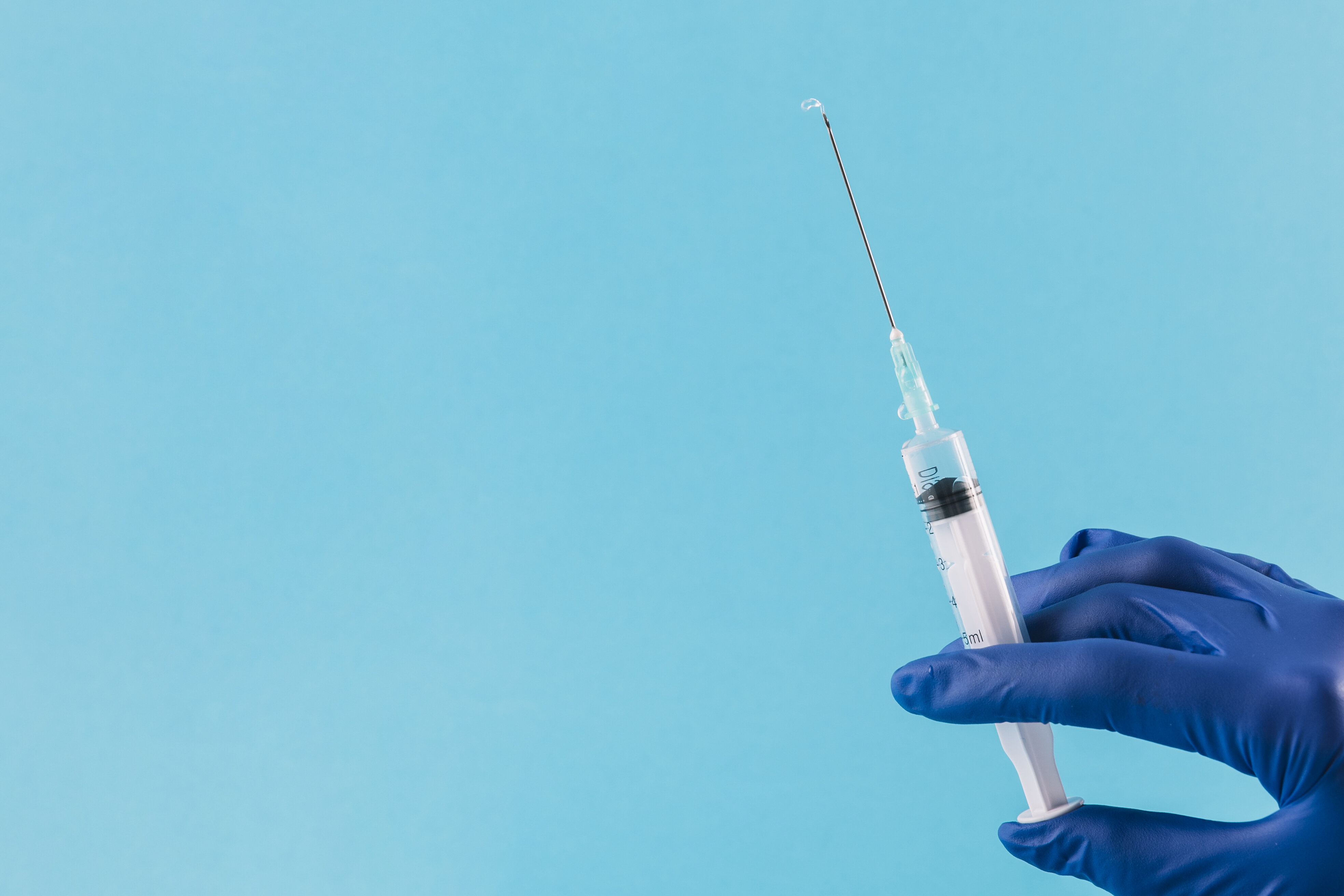 Mão segurando seringa com vacina