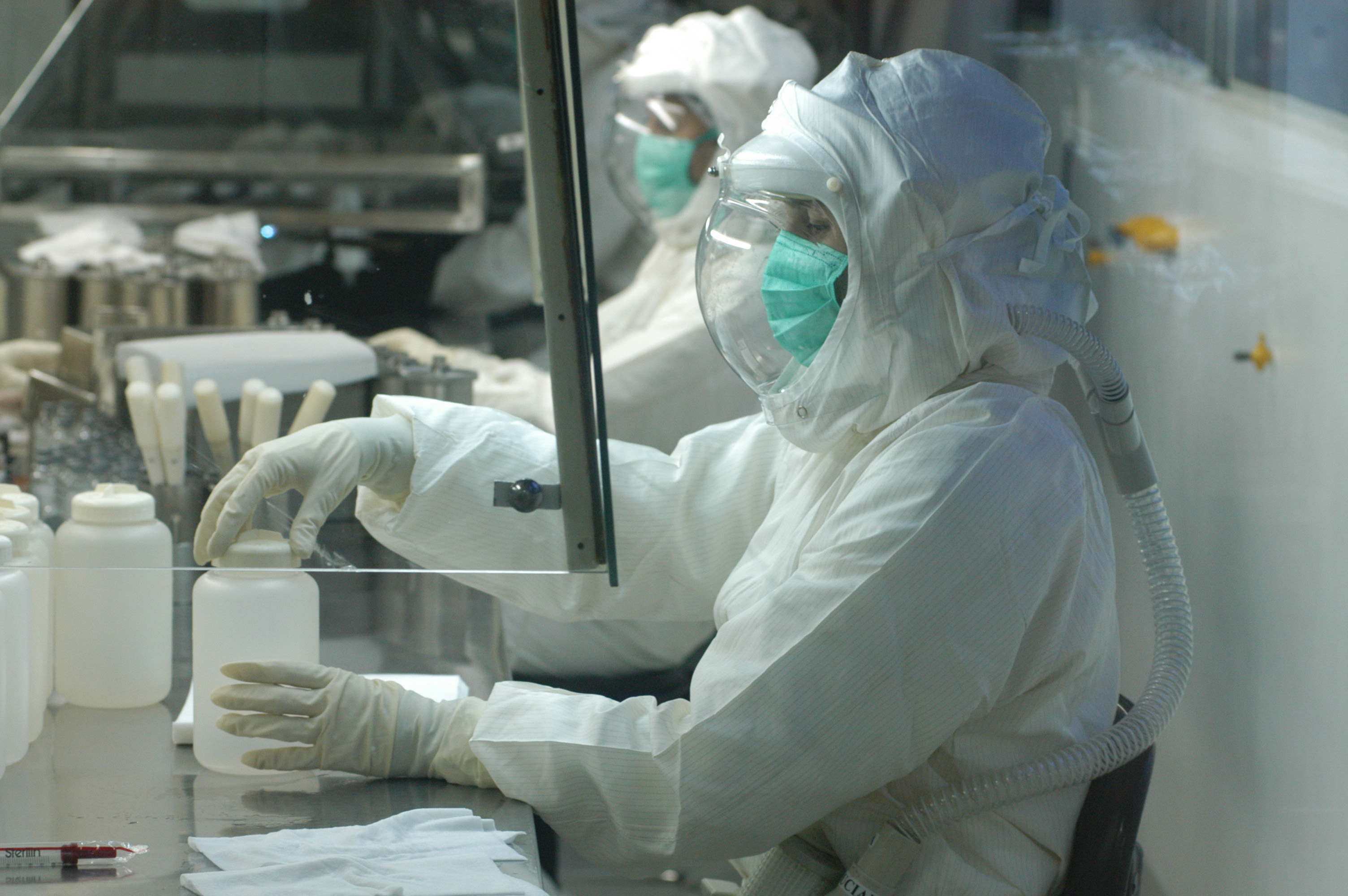 Pessoas em laboratório produzindo vacinas