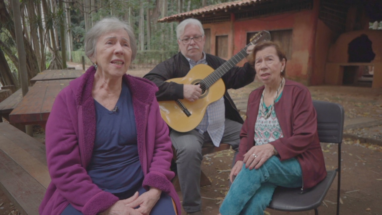 Irmãs Galvão cantando e homem com violão