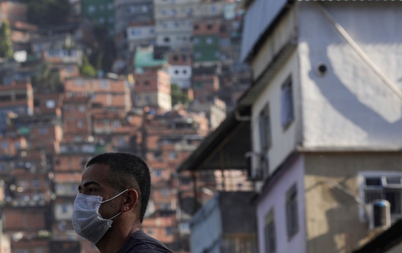 Homem espera ônibus na favela da Rocinha, no Rio de Janeiro