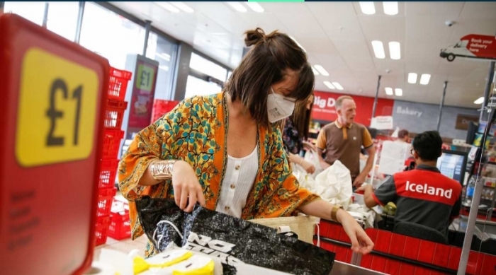 Pessoa de máscara em mercado na Inglaterra