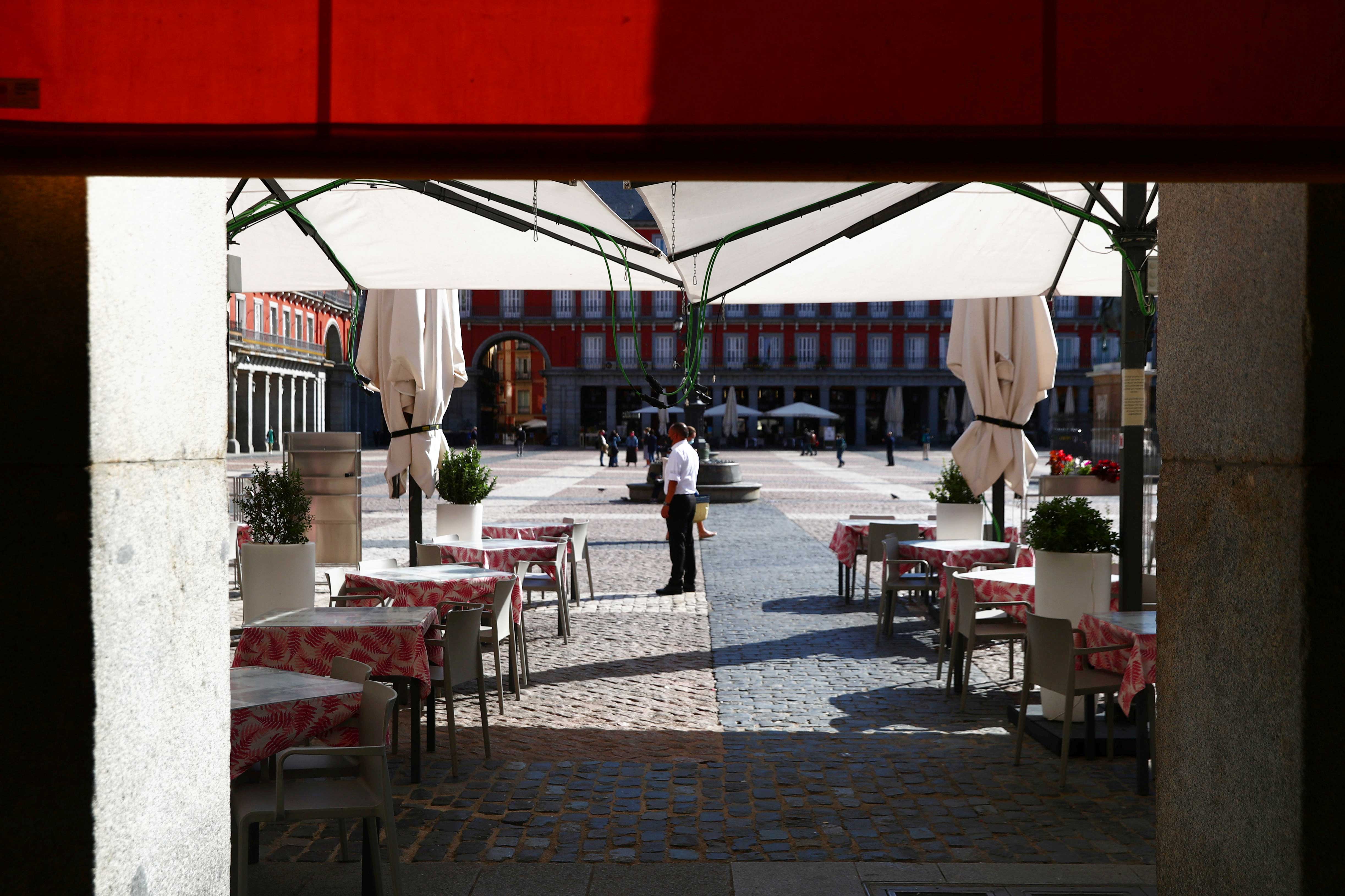 Garçom espera por cliente num restaurante em Madri, em meio à pandemia da Covid-