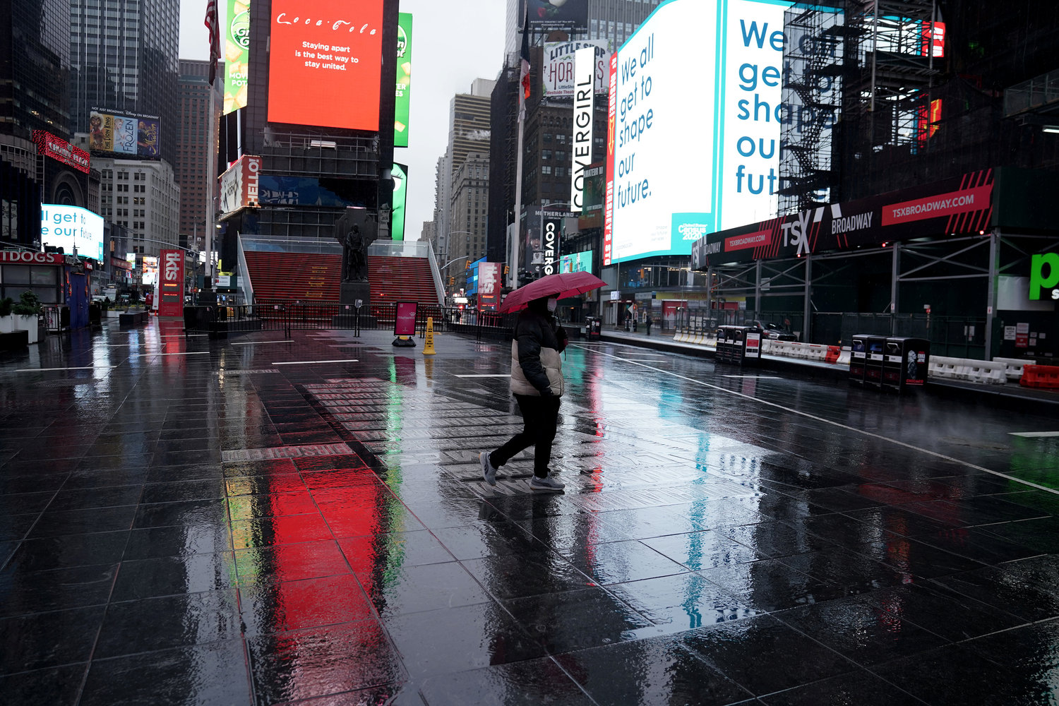 Pedestre caminha na Times Square praticamente vazia