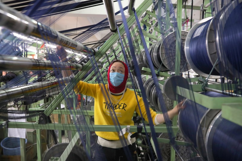 Funcionária de máscara trabalha em fábrica chinesa