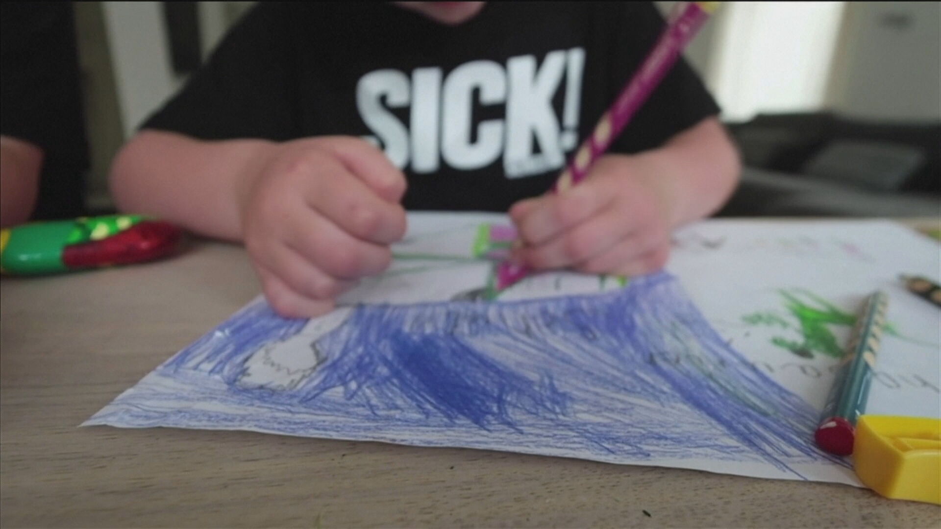 Imagem de criança desenhando sem mostrar o rosto