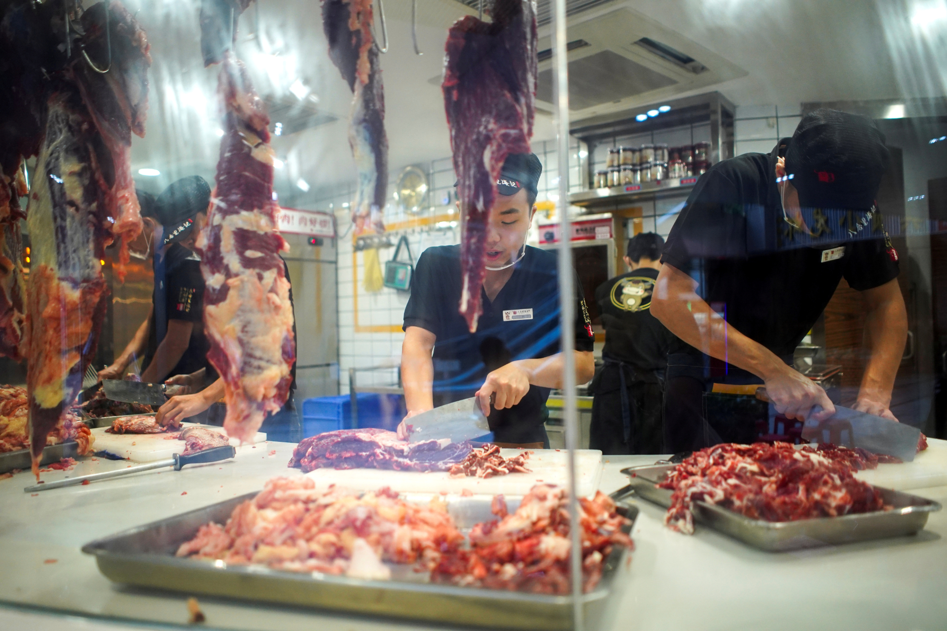 Funcionários cortam carnes em restaurante de Shenzhen, na China