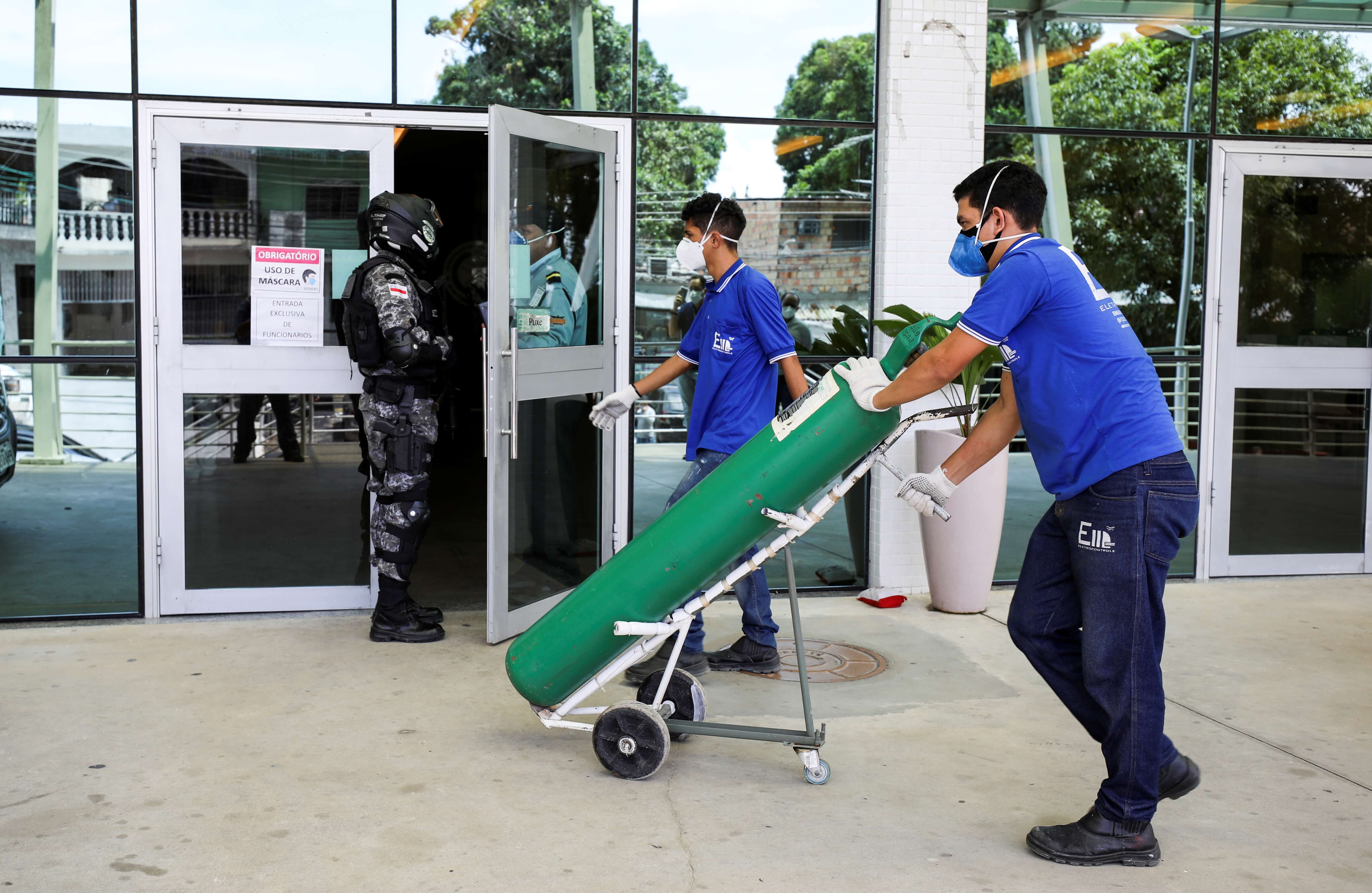 Trabalhadores chegam a hospital em Manaus, no Amazonas, com cilindro de oxigênio
