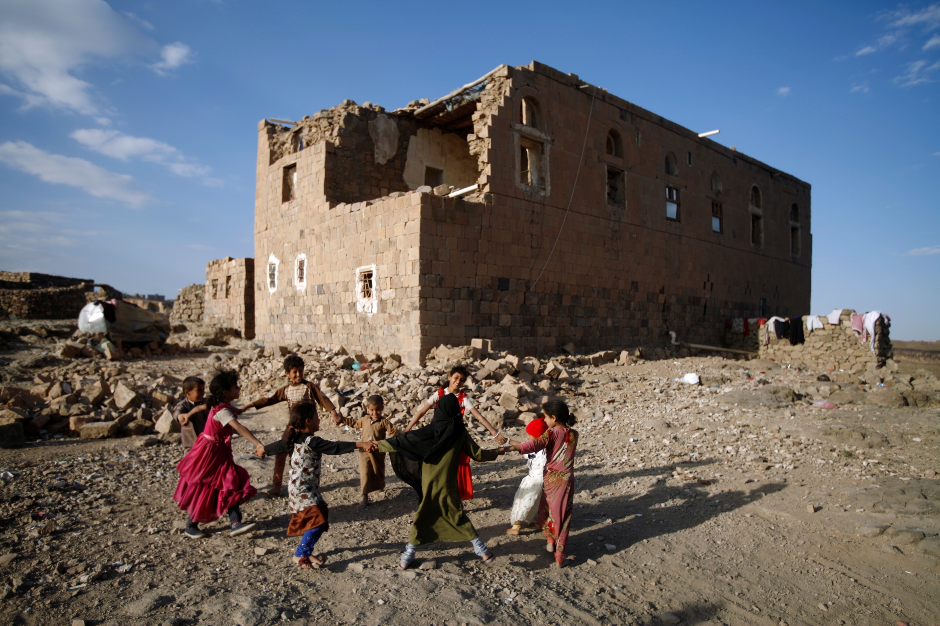 Crianças brincam perto de casa destruída por ataque aéreo nos arredores de Sanaa