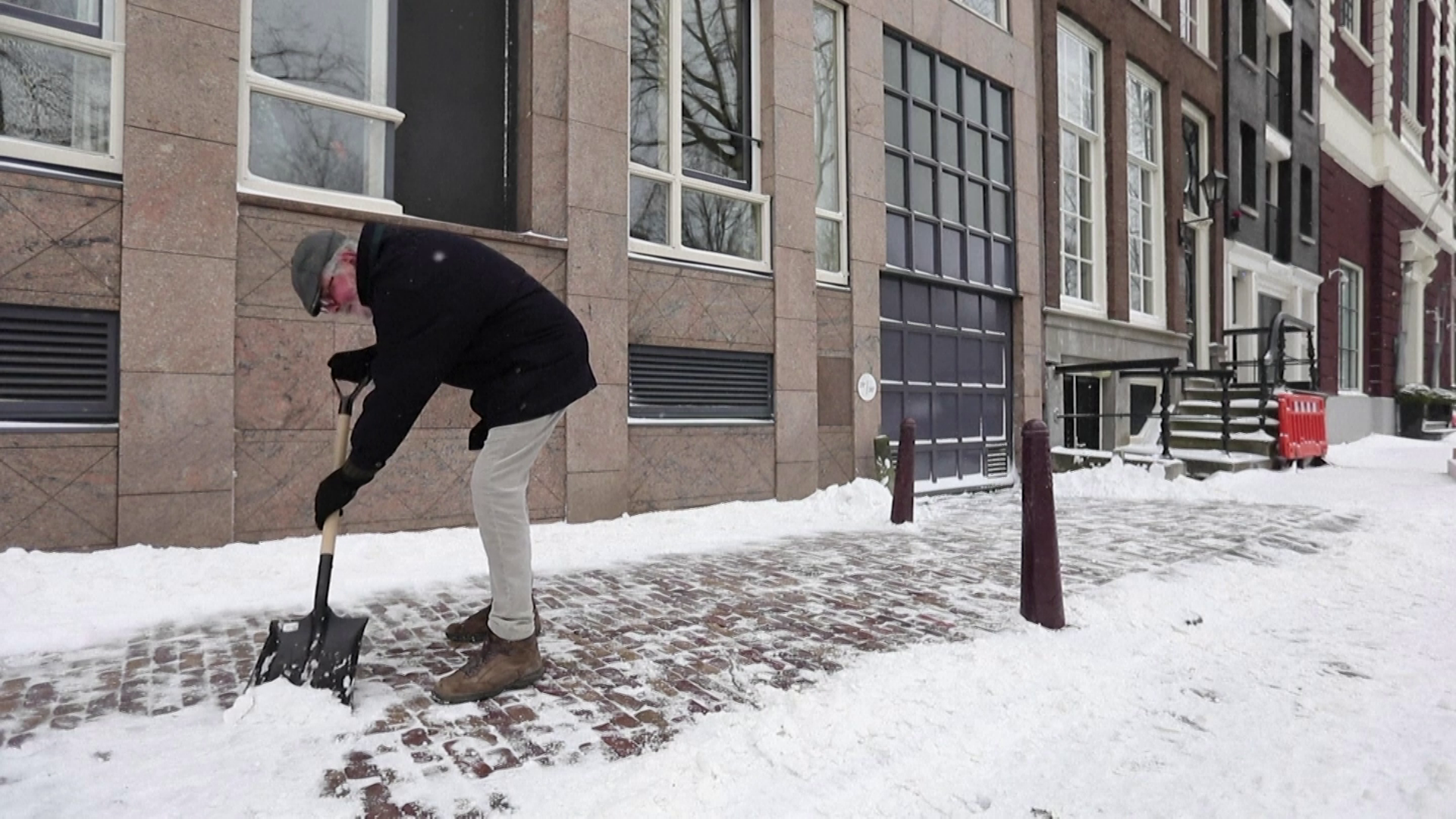 Holandês tira neve de calçada; forte nevasca forçou fechamento de centros de vac