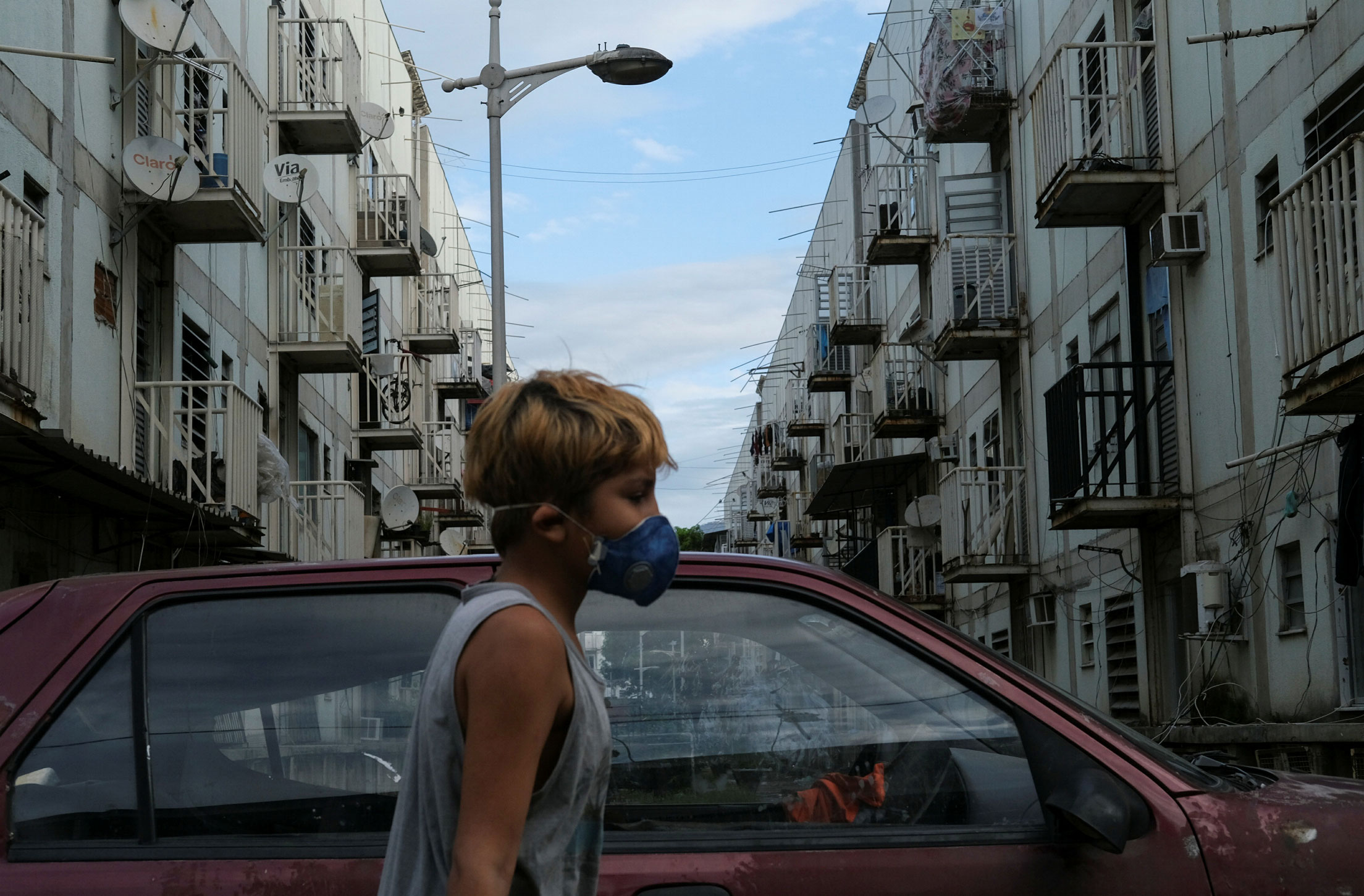 Menino usa máscara de proteção na favela de Manguinhos, no Rio de Janeiro