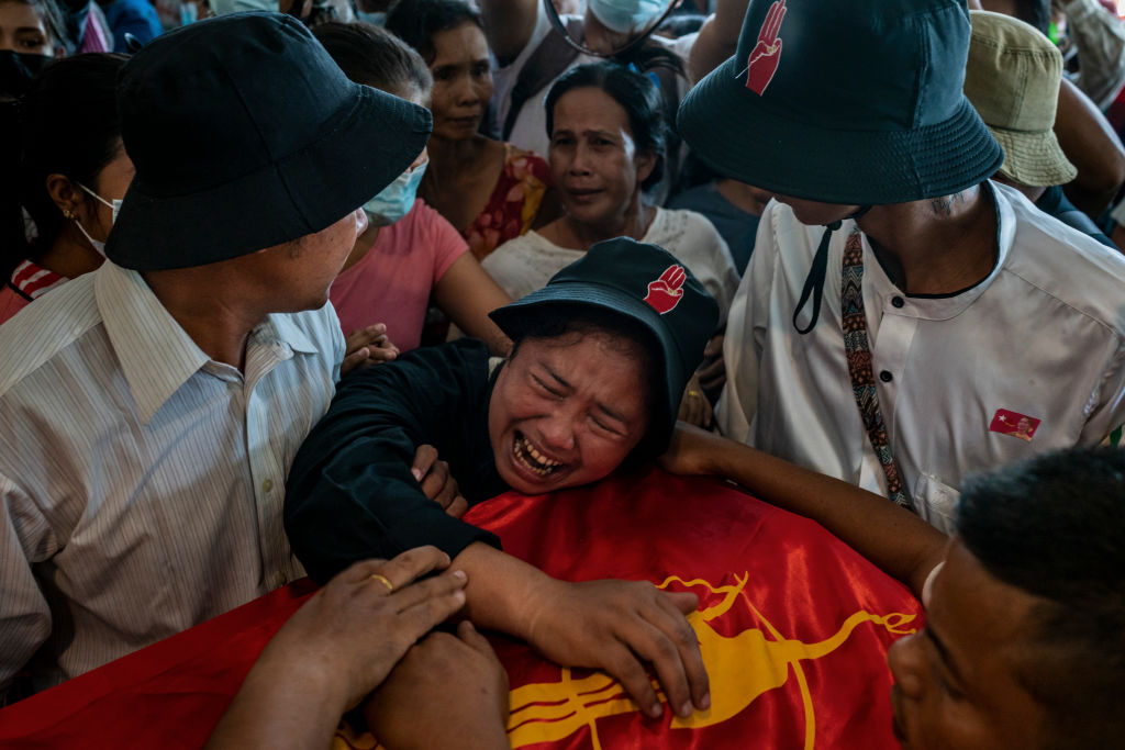 Mulher chora em frente ao caixão do irmão, morto ao protestar contra o golpe