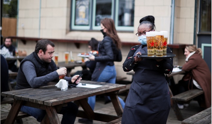 Garçonete serve clientes em pub da Inglaterra