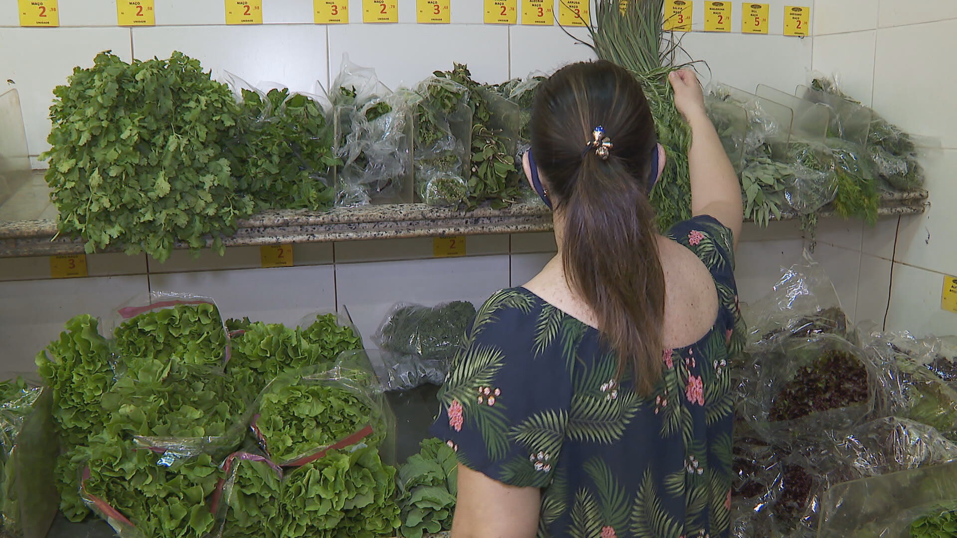 Consumidora escolhe verduras em mercado (18 de abril de 2021)