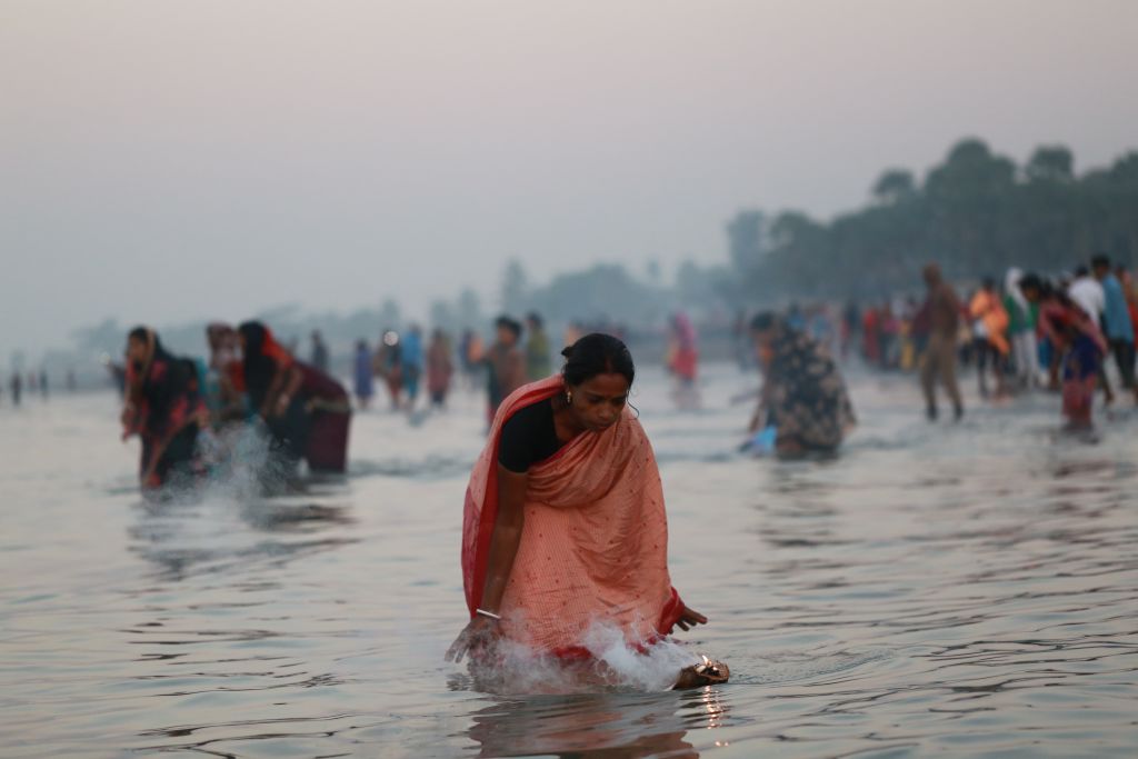 Mulher celebra rito hindu na Baía de Bengala