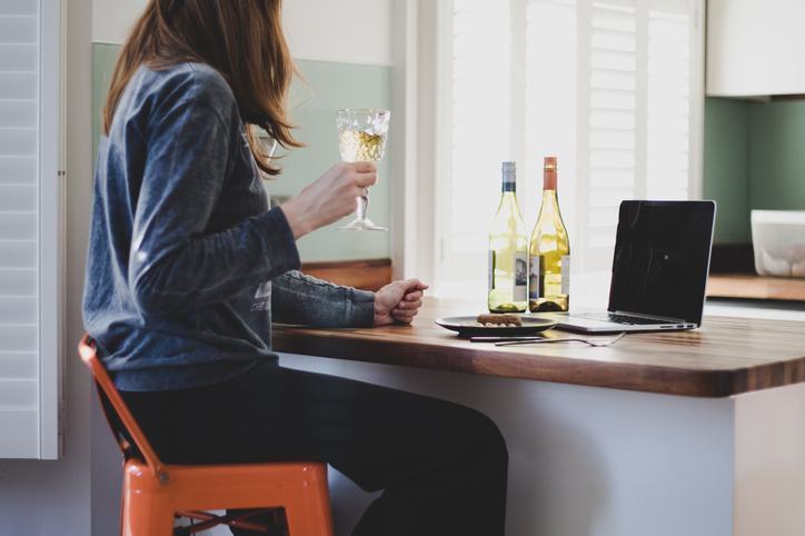 Mulher tomando vinho em casa