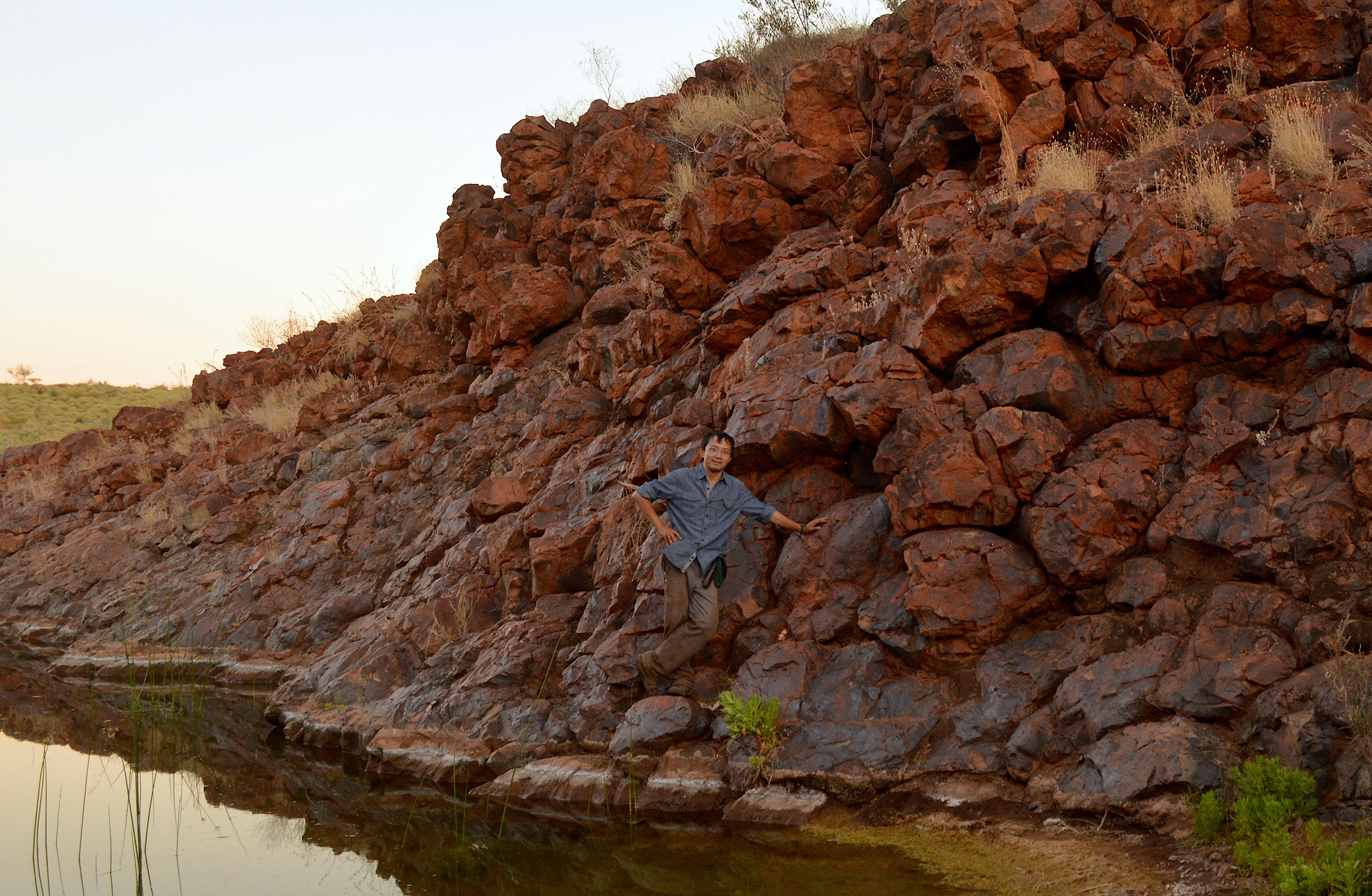 Roger Fu posa ao lado de antigas rochas usadas em estudo sobre as placas tectôni