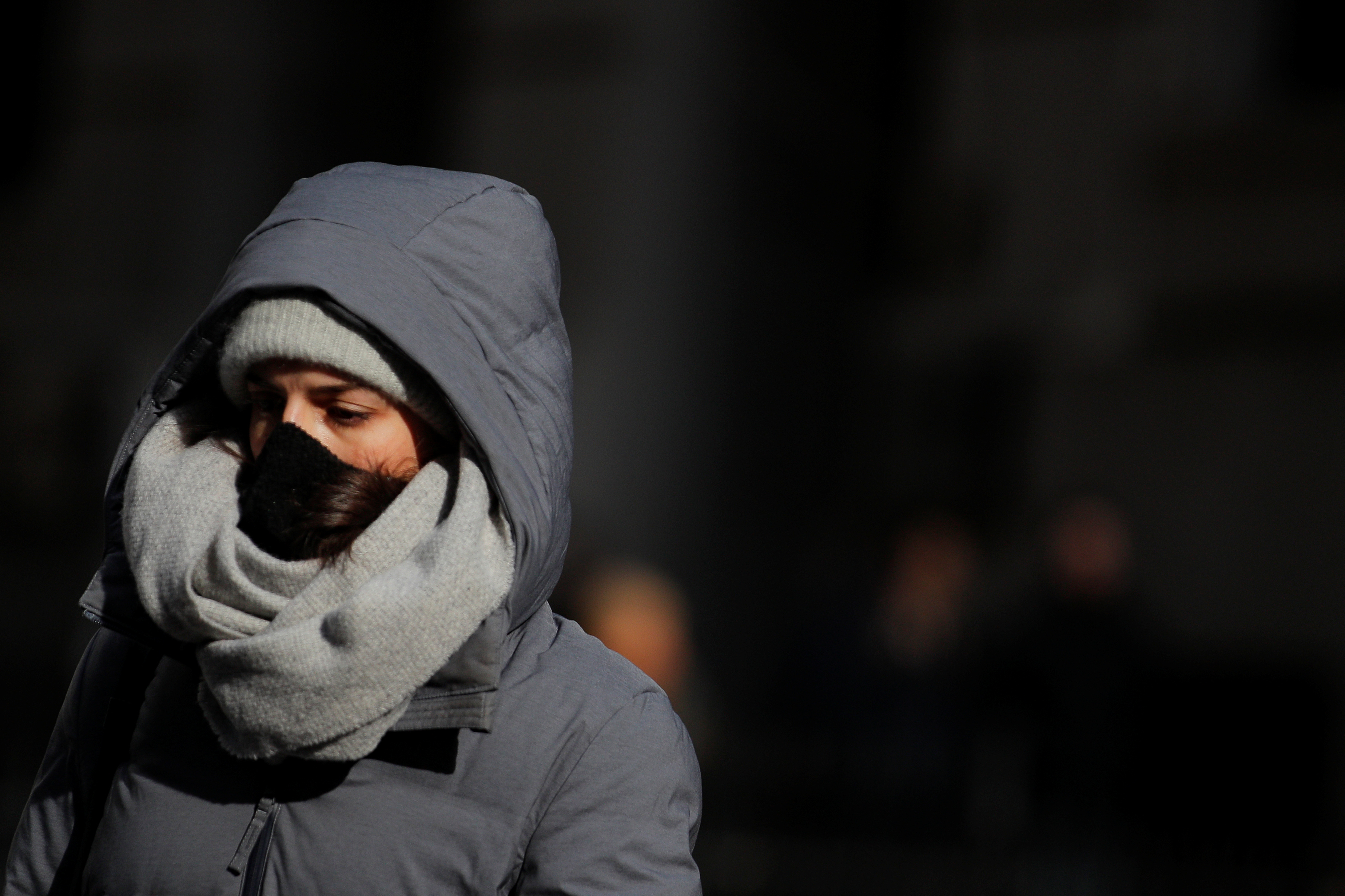 Mulher caminha de máscara em rua de Nova York
