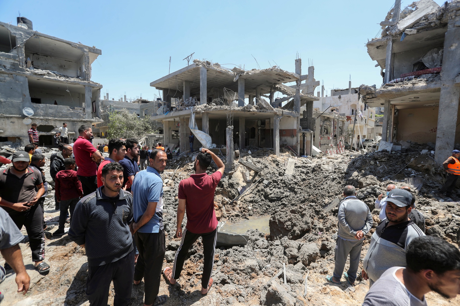 Palestinos se reúnem perto de casas destruídas por ataque de Israel em Gaza