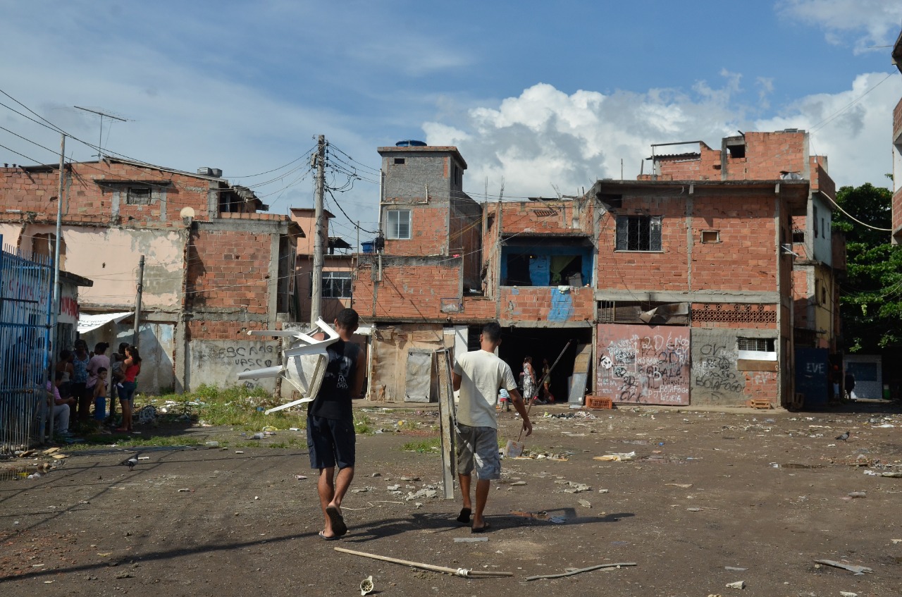 Jovens andam pela favela Metrô-Mangueira, situada ao longo da Avenida Radial Oes