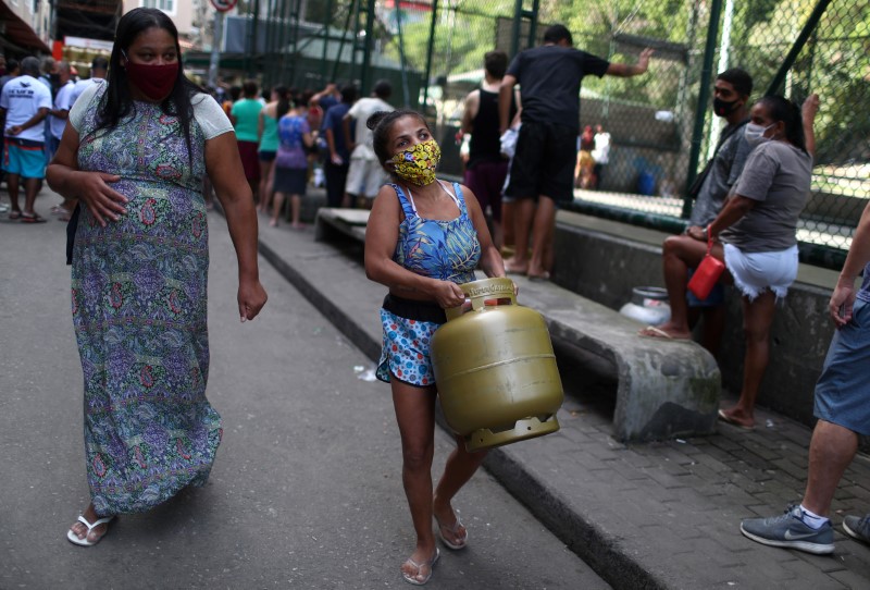 mulher carrega botijão de gás 