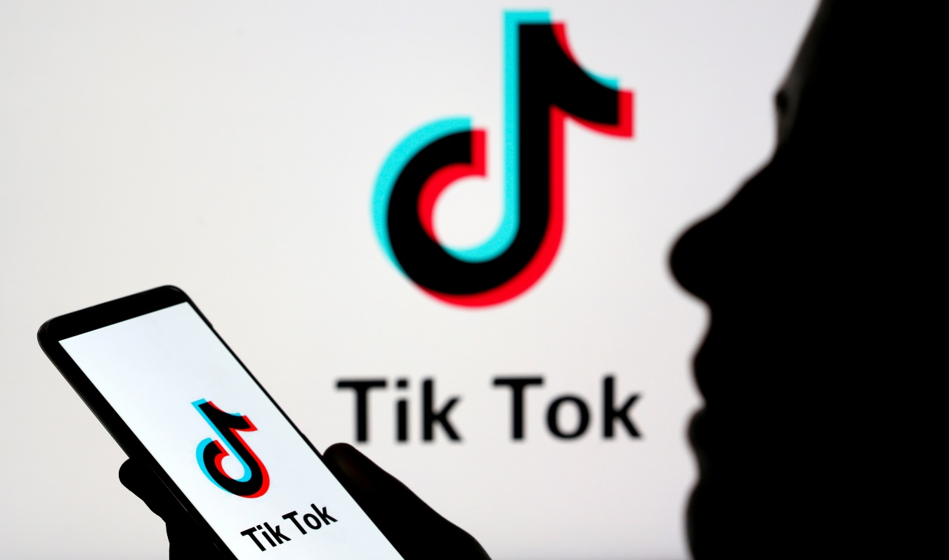 Pessoa manipula smartphone com logotipo da TikTok