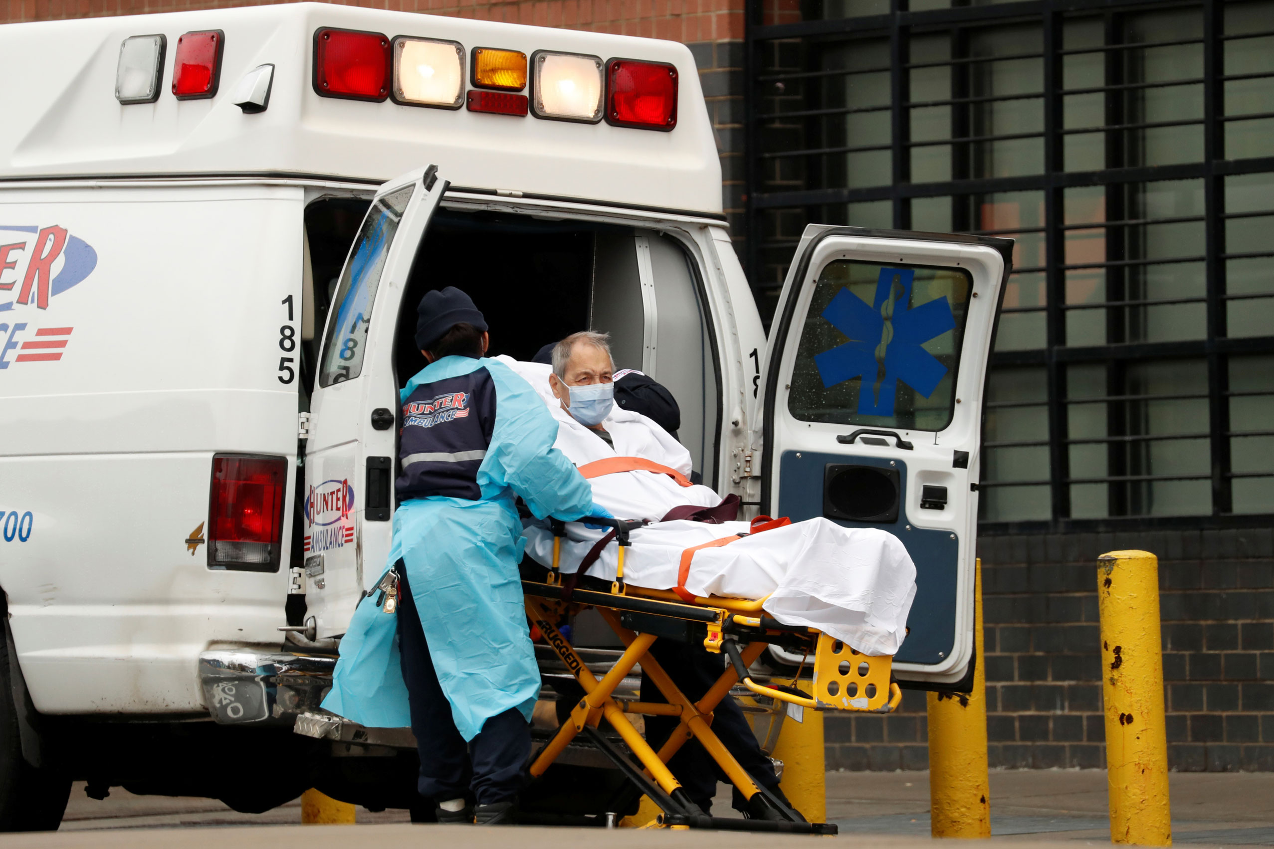 Paciente com Covid-19 é transportado para dentro de ambulância em Nova York