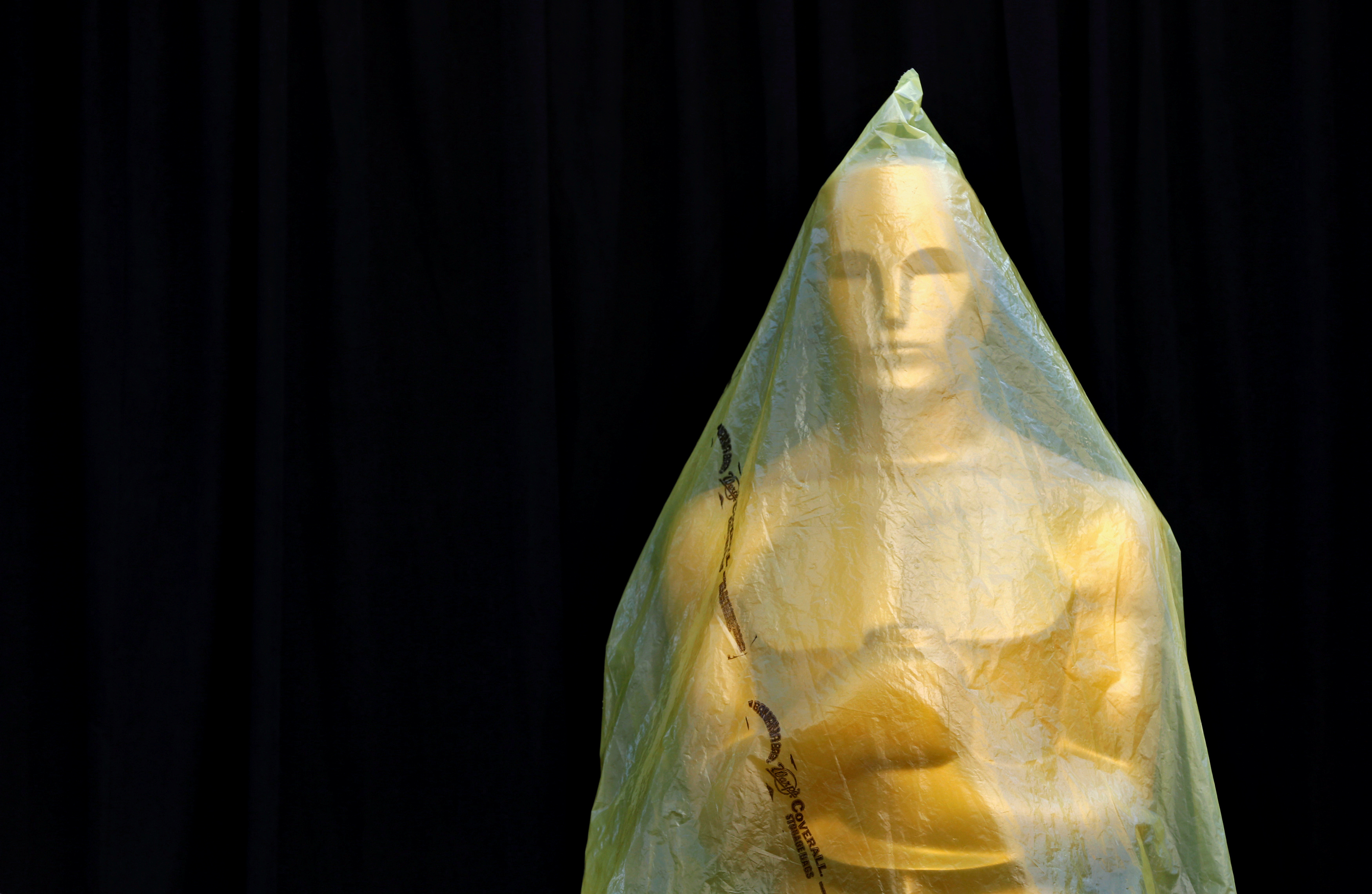 Estátua do Oscar coberta em plástico durante preparativos para cerimônia