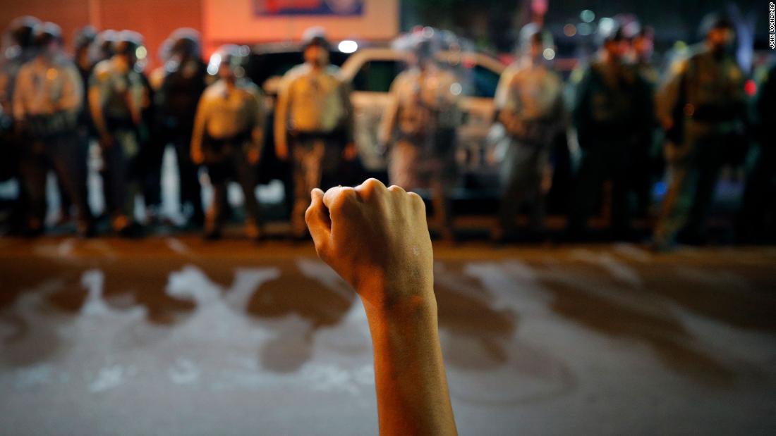 Um manifestante levanta o punho durante uma manifestação.