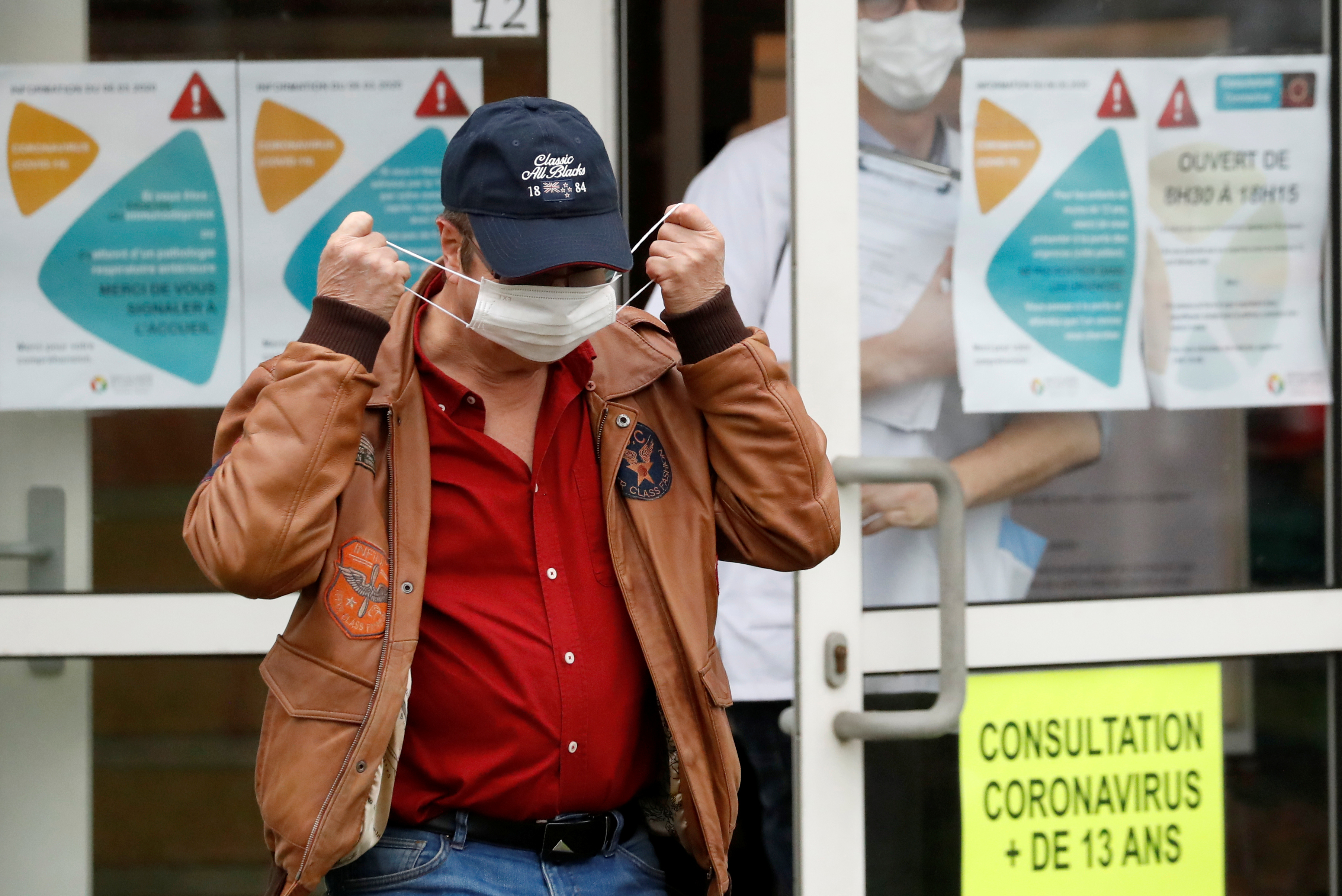 Homem veste máscara de proteção em frente a hospital em Vannes, França