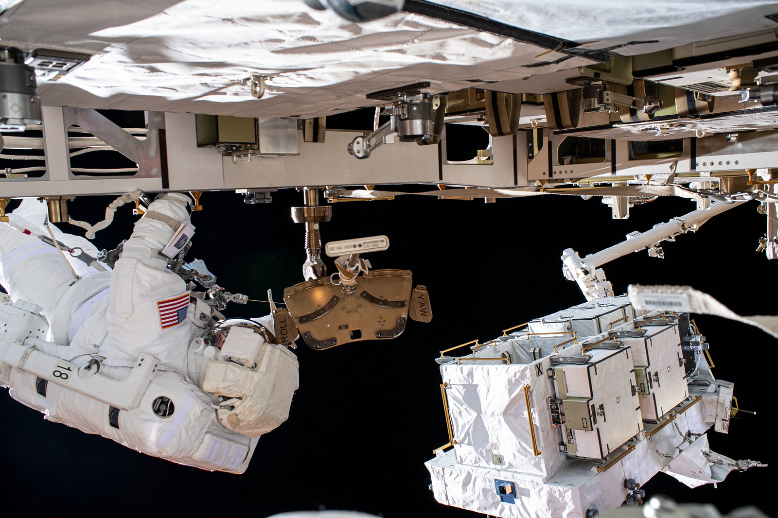 Astronauta Robert Behnken (E) troca baterias da Estação Espacial Internacional