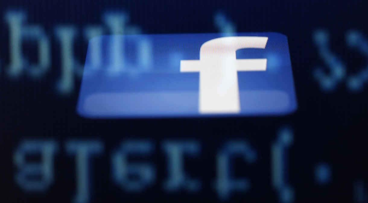 A Facebook logo on an Ipad is reflected among source code on the LCD screen of a computer, in this photo illustration taken in Sarajevo June 18, 2014. REUTERS/Dado Ruvic