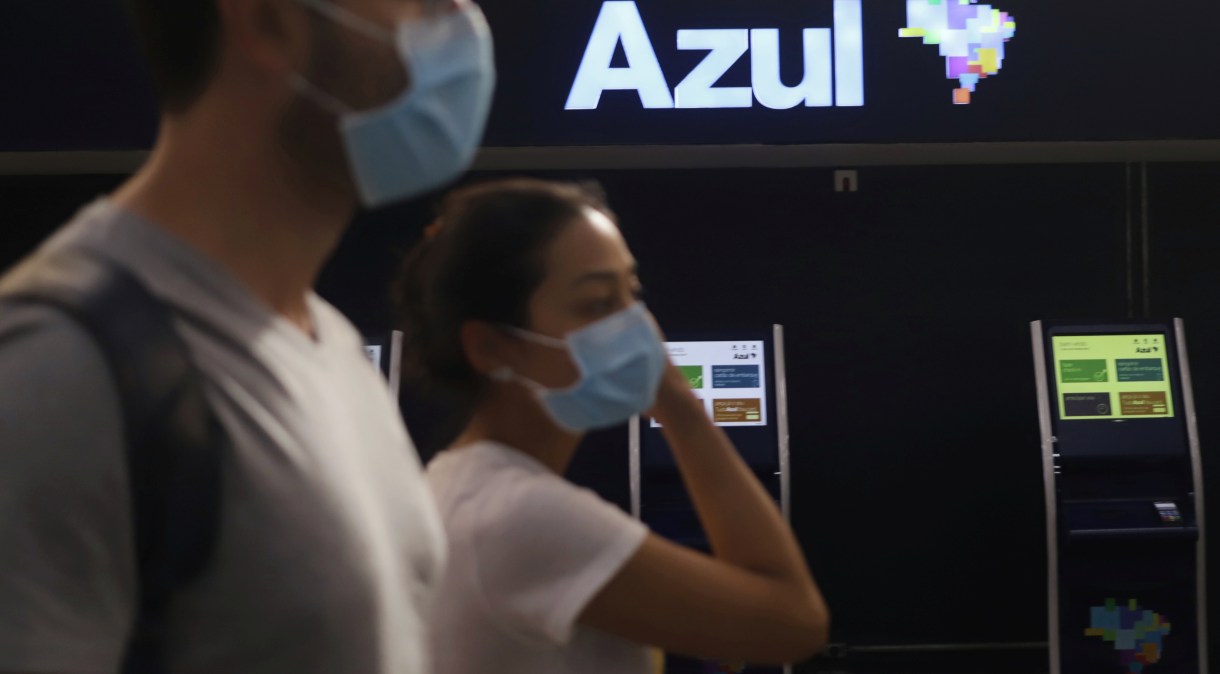 Passageiros com máscaras de proteção caminham em frente a guichês da Azul no aeroporto de Congonhas, em São Paulo (11.mar.2020)