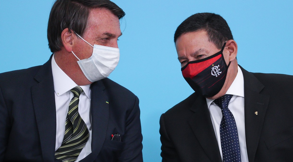 O presidente da República, Jair Bolsonaro, e o vice-presidente, Hamilton Mourão, usam máscaras durante solenidade em Brasília