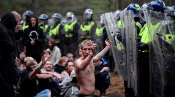 Dezenas de policiais, alguns segurando escudos de proteção, abordaram os participantes na floresta de Thetford