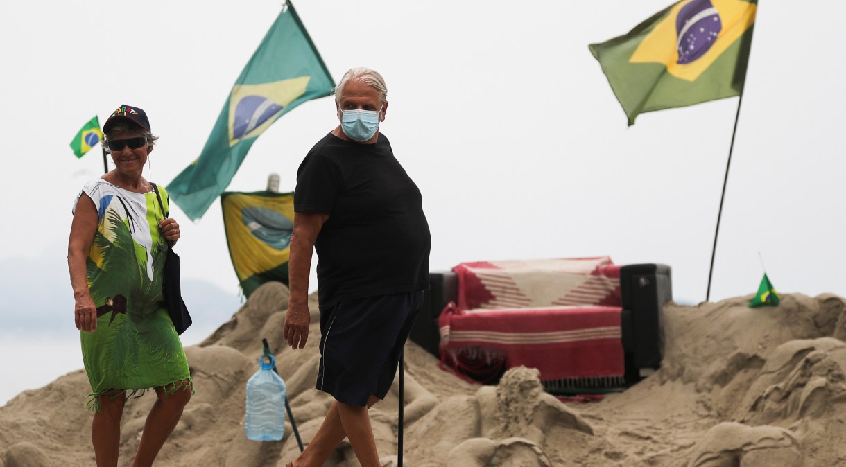Homem usa máscara para se proteger de coronavírus na praia de Copacabana, Rio de Janeiro